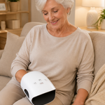Adulto mayor usando el masajeador de manos PulseHand en el sofa